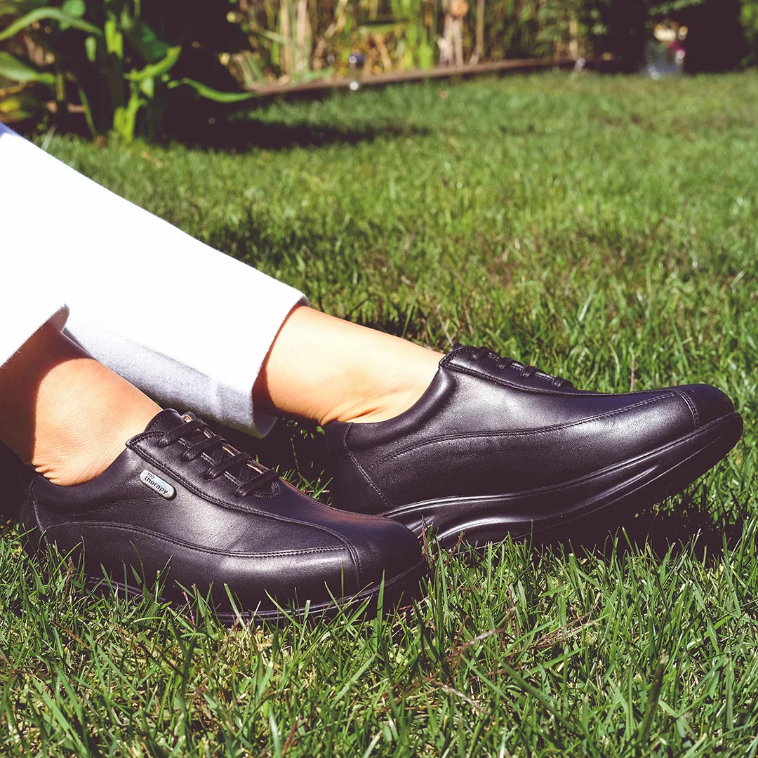 Lifestyle image of woman wearing orthopedic rocker bottom shoes for wide feet, designed by TDO Therapy.