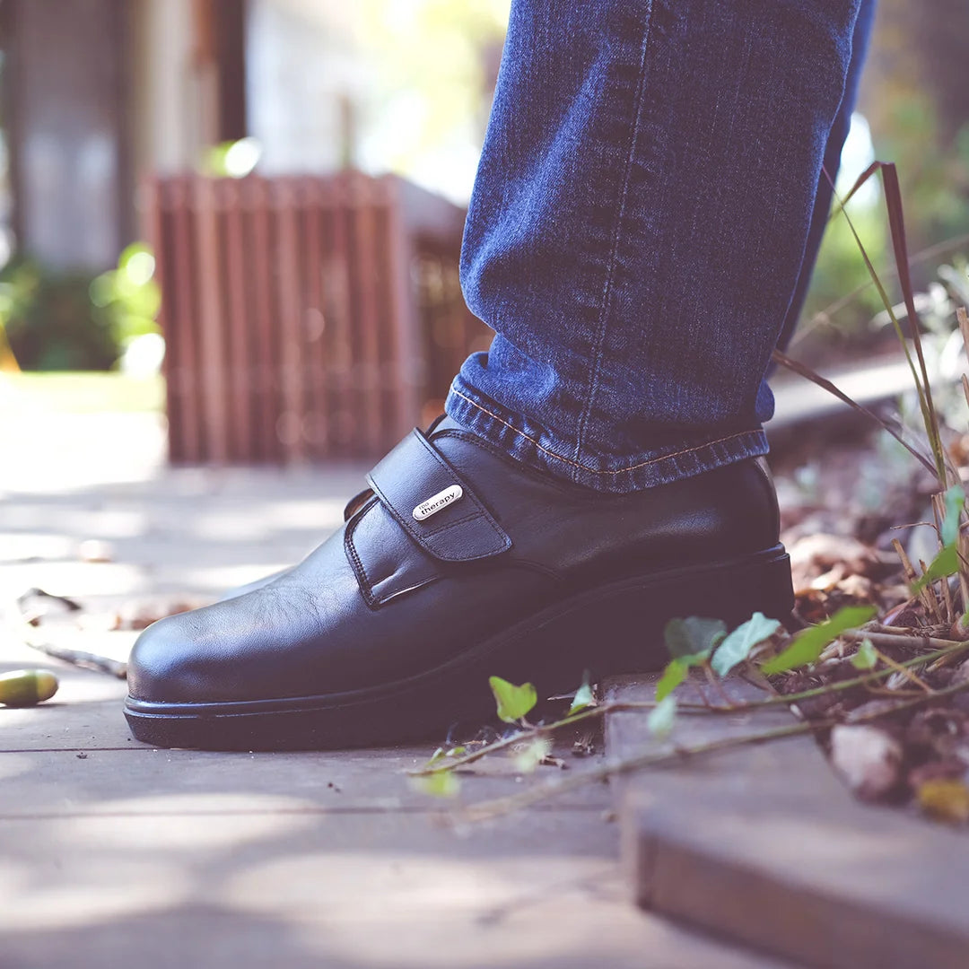 Man walking outdoors in supportive extra wide and deep orthopedic shoes from TDO Therapy, ideal for foot conditions like bunions and diabetes.