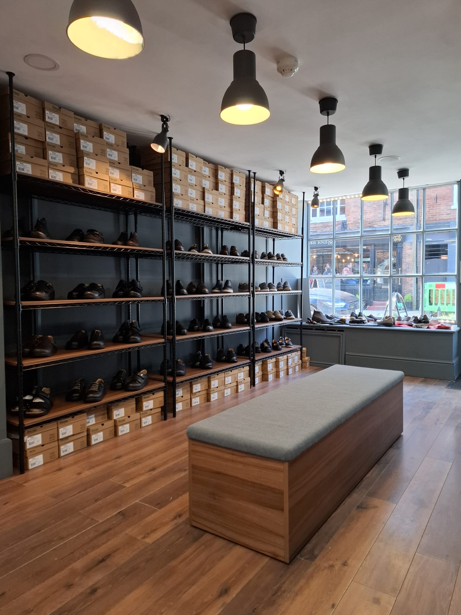 Alt text: Specialist measuring foot during orthopaedic shoe fitting in Farnham